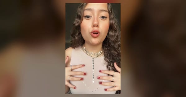 Modelo mostrando anéis nas mãos e colares Plaka sobre uma blusa clara.